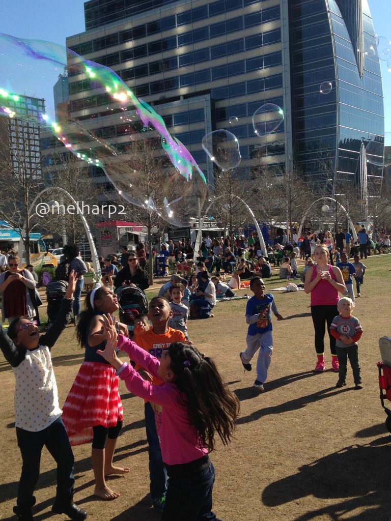 kids playing with bubbles in park